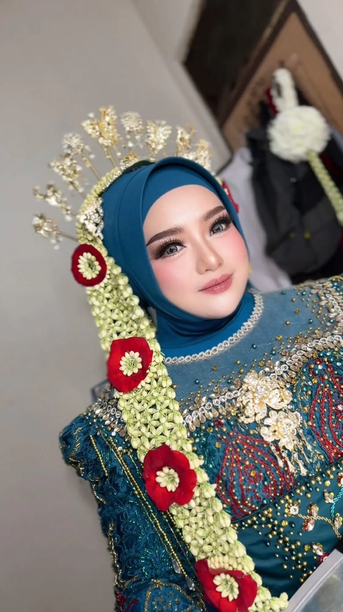 Pengantin Sheilvia berhijab toska dengan mahkota emas dan ronce melati